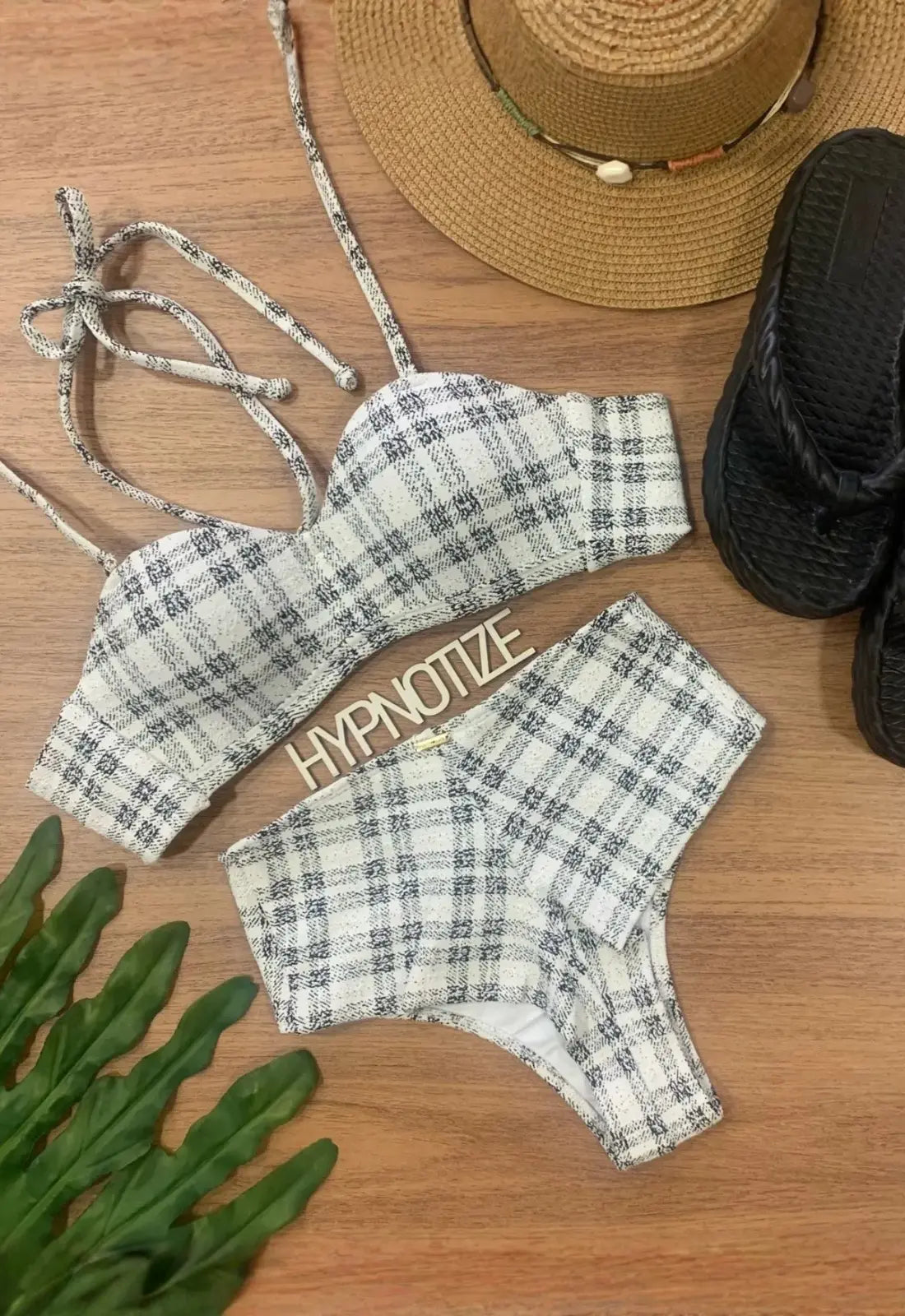 Bikini off white con top palabra de honor y braguita alta, junto a accesorios de playa.